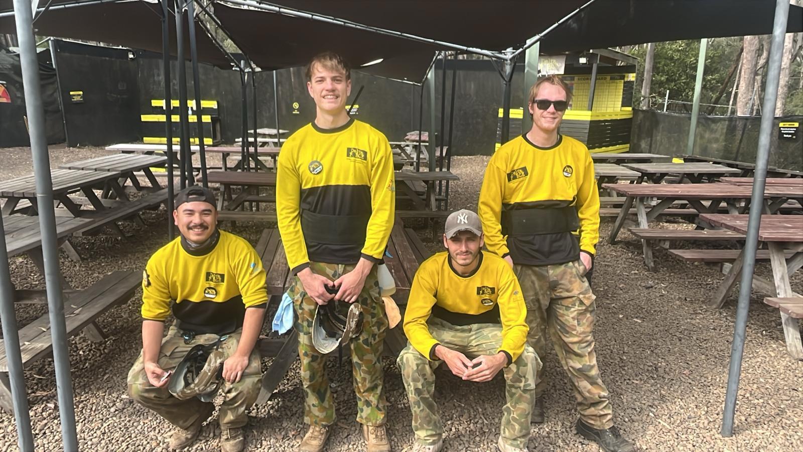 Four smiling Delta Force marshals together in the base camp